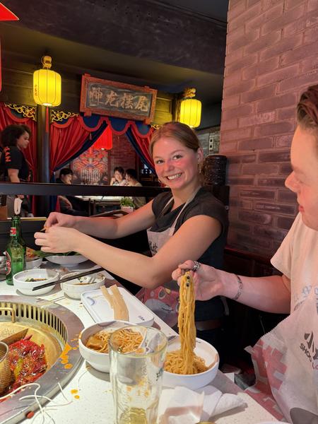 This lively photo captures friends enjoying a hot pot meal at a restaurant on Lange Leidsedwarsstraat, Centrum, Amsterdam
